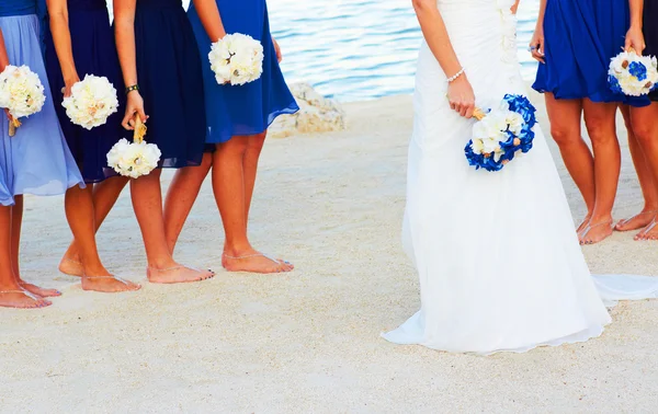 Bride and her friends at the beach with bouquets