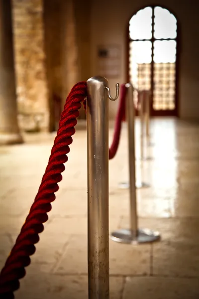 Red barrier rope on window background.