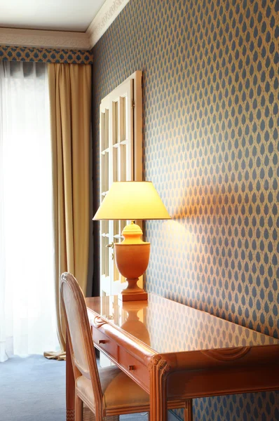 Interior luxury apartment, detail room, table lamp and wooden desk