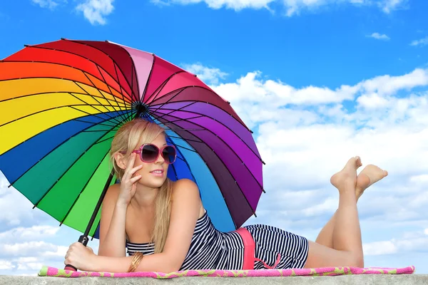 Glamorous girl in retro style by color umbrella on the beach