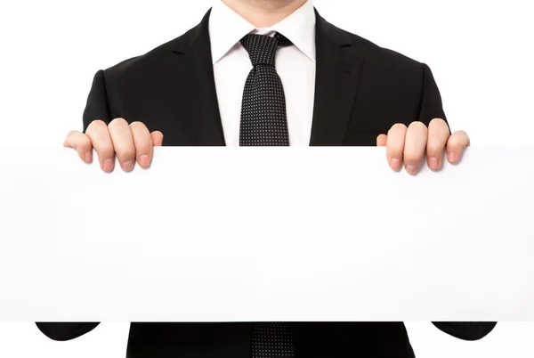 Isolated businessman holding a large white sheet of paper or ban