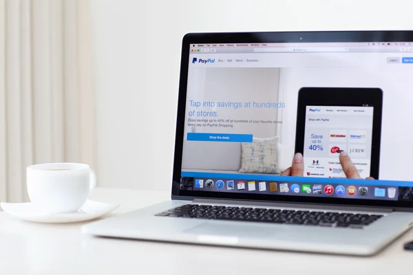 MacBook Pro Retina with PayPal home page on the screen stands on