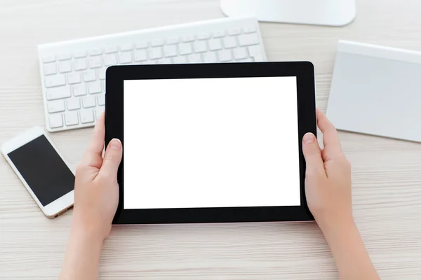 Female hands holding a tablet with a isolated screen over a tabl