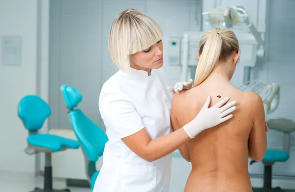 Doctor examining woman skin