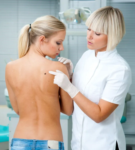 Doctor inspecting woman patient skin
