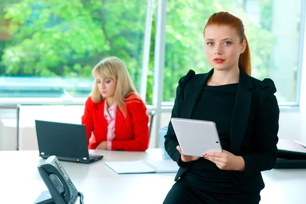 Attractive business woman in office with tablet
