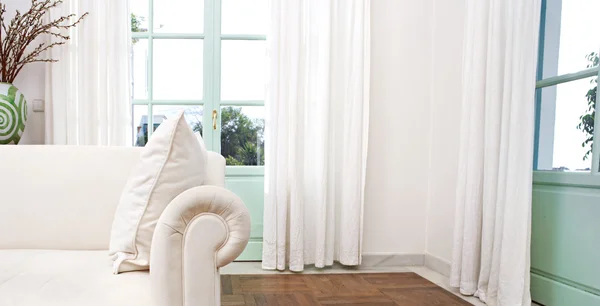 Stylish home living room with white sofa and glass doors.