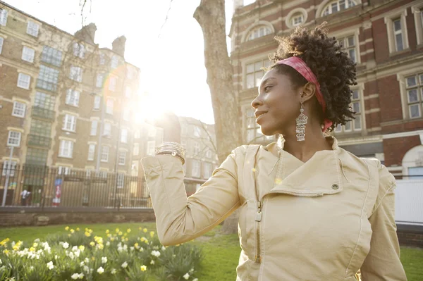 Young african american woman holding the sun in her hand at sunset in the city of London.