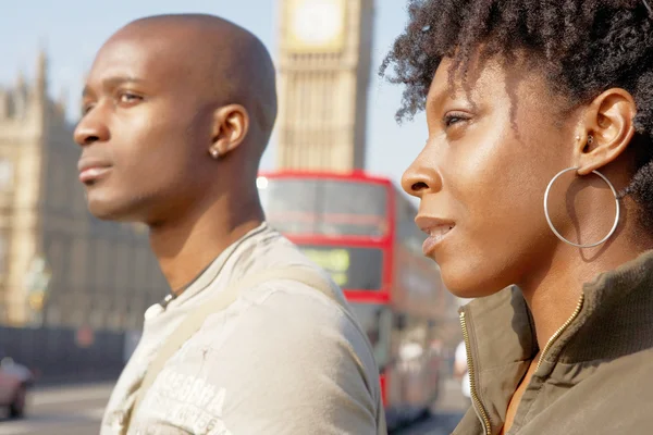 Attractive black tourist couple walking past Big Ben