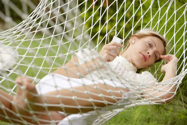 Young beautiful woman laying down on a hammock while on vacations