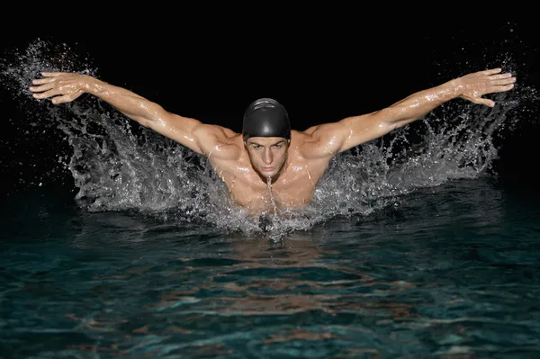 Olympic swimmer training for the butterfly stroke in a swimming pool.