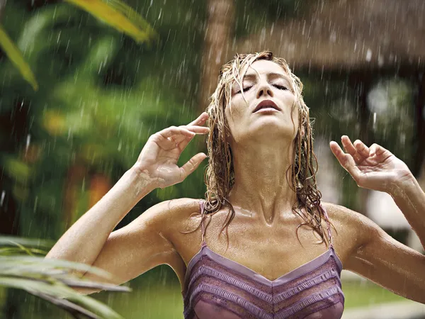 Attractive young woman under the tropical rain