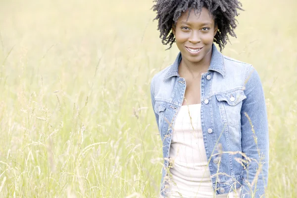 Young black woman standing in a yellow field