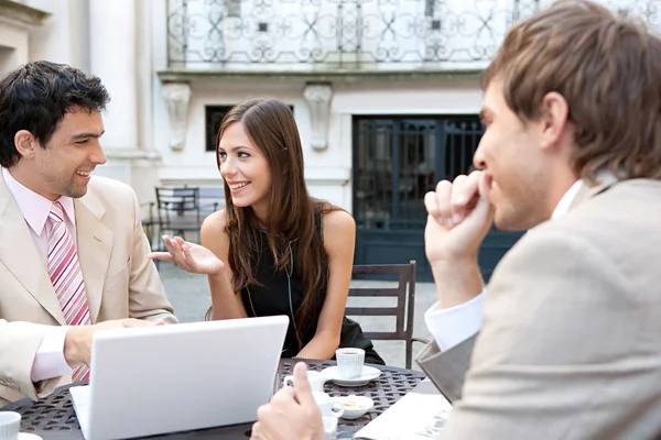 Three business sharing a table at a coffee shop terrace