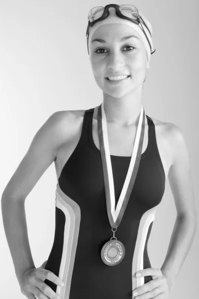 Black and white portrait of a young olympic swimmer proundly wearing a gold medal