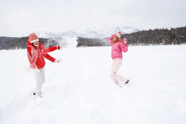 Two girls playing games and having fun in in winter