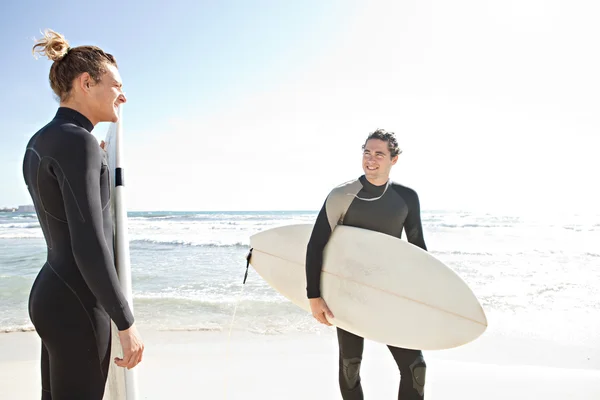 Two friends surfers standing