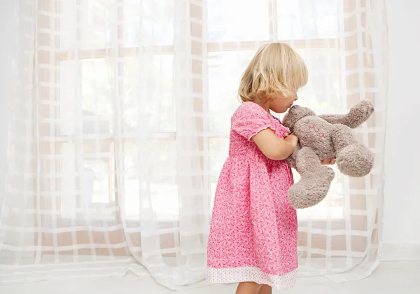 Girl child playing with teddy bear