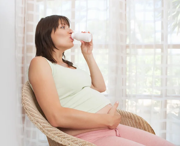Pregnant woman drinking healthy vitamins