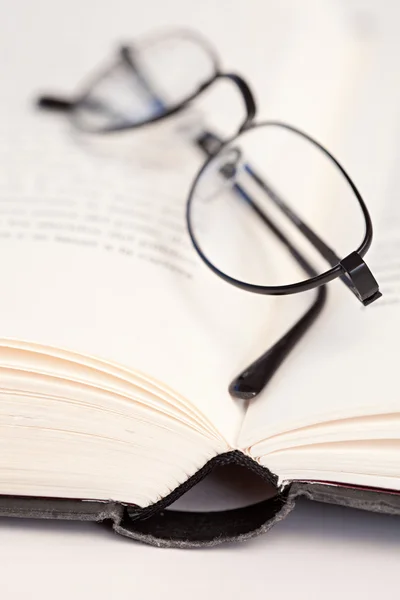 Reading glasses laying on a white desk