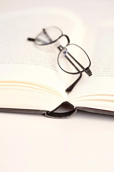 Reading glasses laying on a white desk