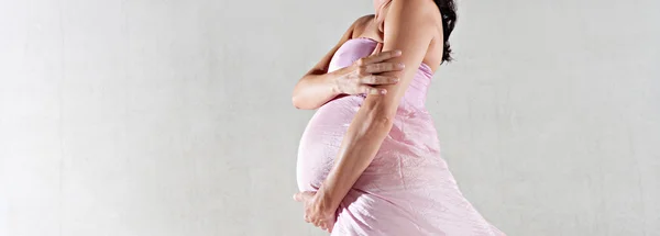 Pregnant woman wrapped in pink silk