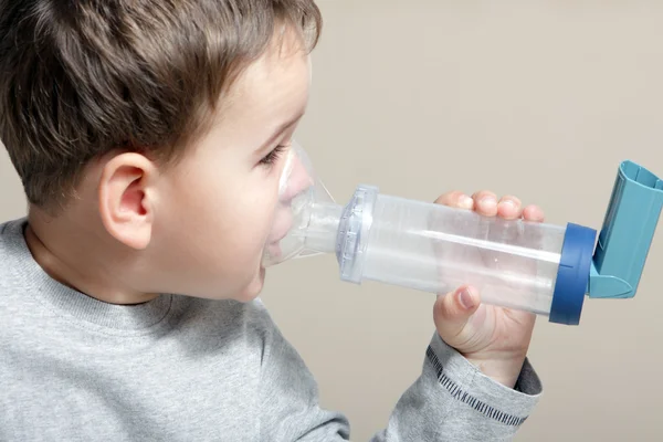 Boy using inhaler for asthma.