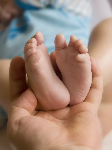 Soft holding her child's little feet