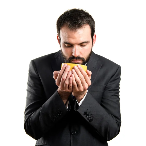 Young businessman drinking a coffee over white background