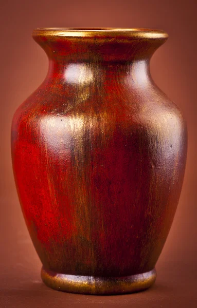 Ancient clay vase on brown background