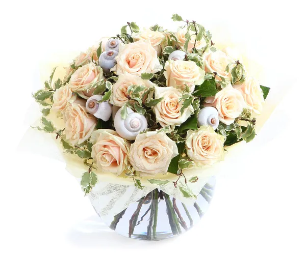 Flower arrangement with cream roses and seashells, a transparent glass vase. Isolated on white background. Floral composition. Flower composition