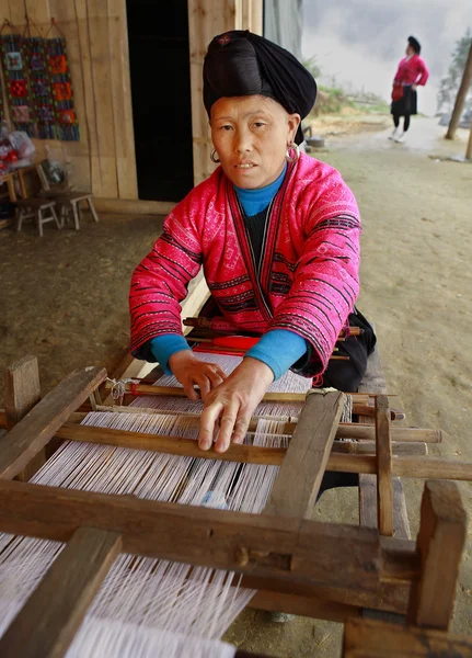 Red Yao Women in Xiaozhai Village, Longsheng County, Guangxi Province, China. Woman red Yao nationality, ethnic minority groups in China, weaves on an old loom made of wood, April 4, 2010.