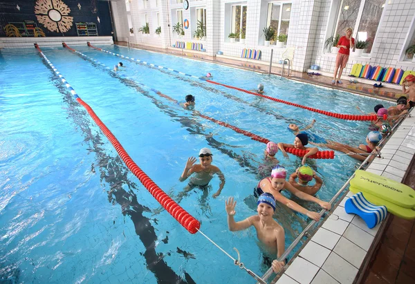 Schoolchildren swim in the covered sports public swimming pool.