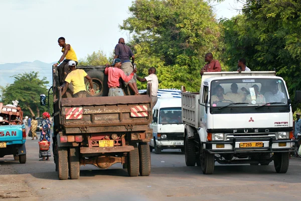 African men make trip back of a truck.