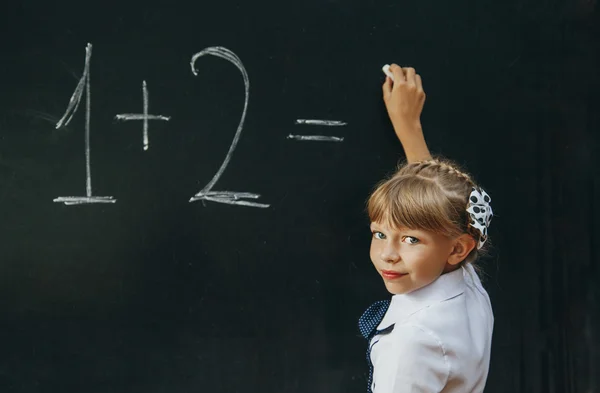 Happy school girl on math classes finding solution and solving problems