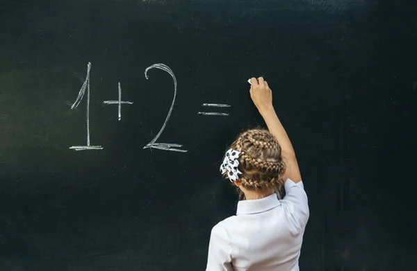 Happy school girl on math classes finding solution and solving problems