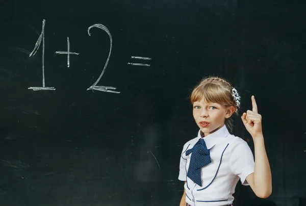 Happy school girl on math classes finding solution and solving problems