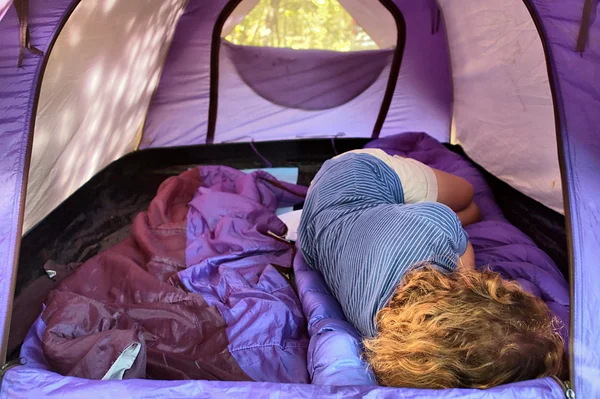 Woman sleeping inside blue tent
