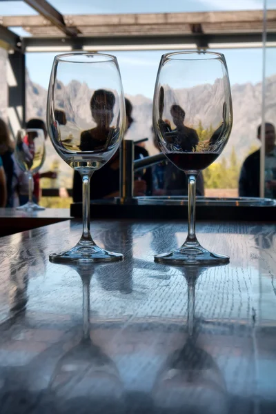 Two glasses against window and mountains