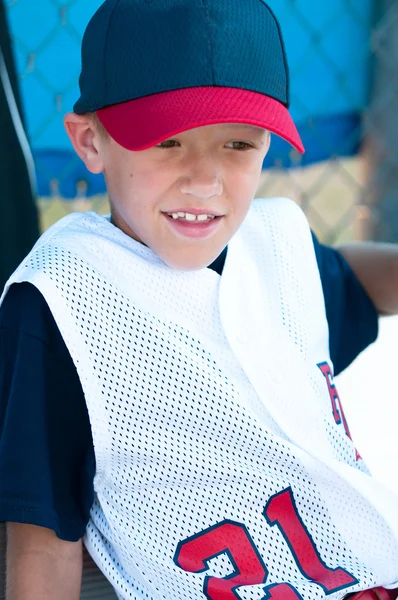 LIttle league baseball player in dugout