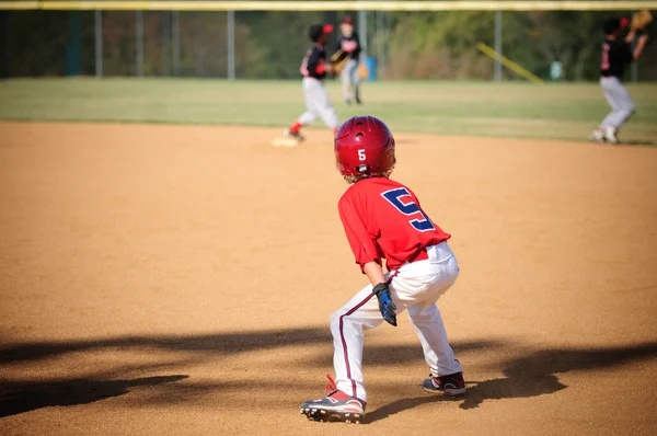 Little league baseball player trying to steal