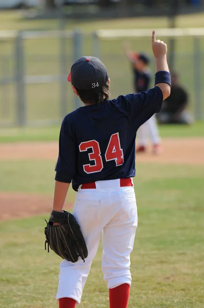 Youth ballplayer holding up finger.