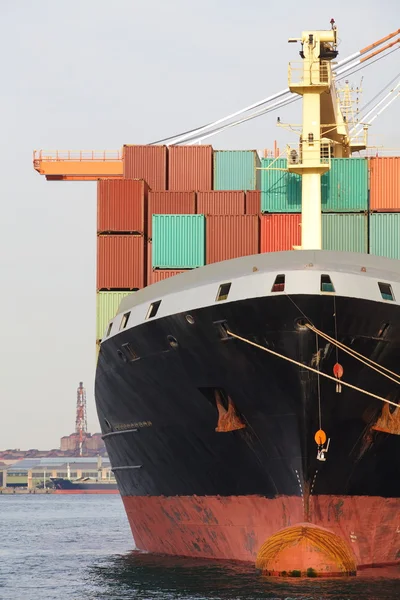 Container Cargo freight ship with working crane bridge in shipyard