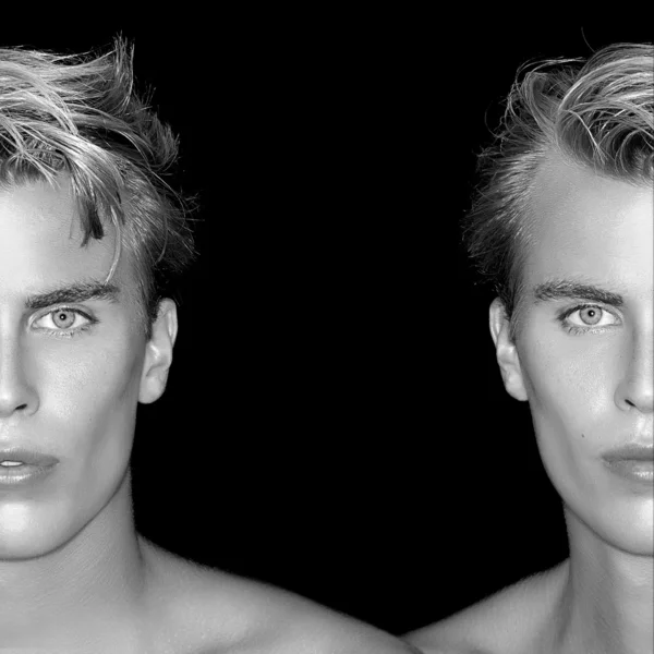 Twins. Two Half Faces of Blond men on Black Background