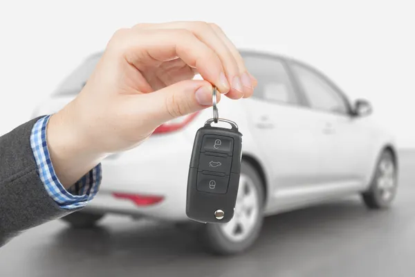 Male holding car keys with remote control system