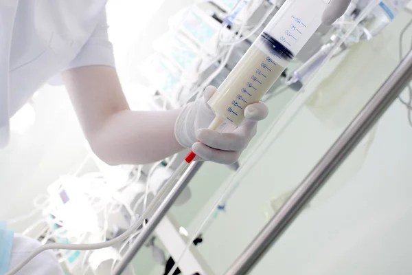 Nurse conducts tube feeding in the ICU