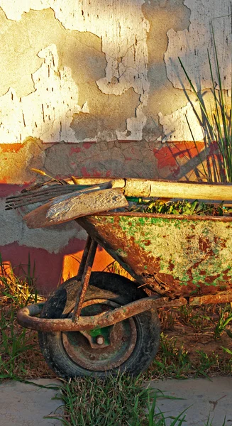 Gardening tools in old rusty wheelbarrow