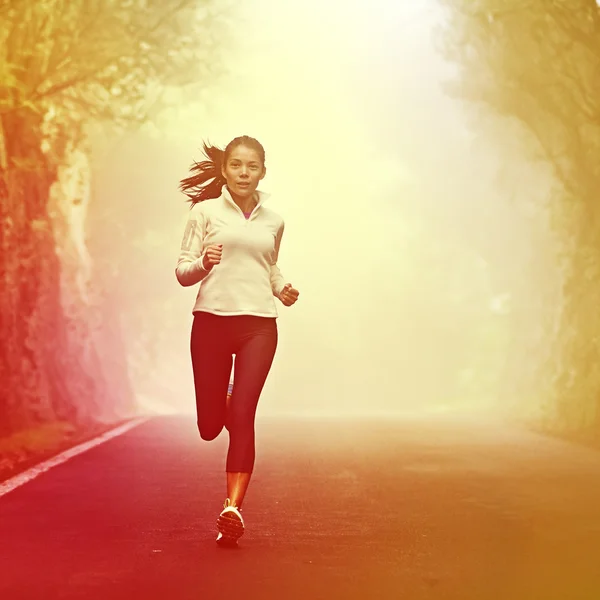 Running woman jogging on road