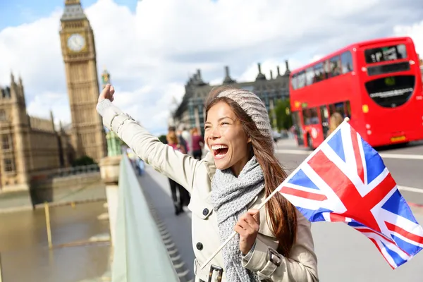London - happy tourist holding UK flag by Big Ben