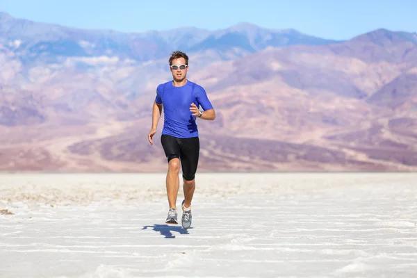 Running man - sprinting athlete runner in desert